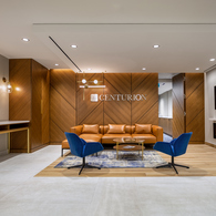 A lobby with a Centurion sign and a couch at Centurion's head office.